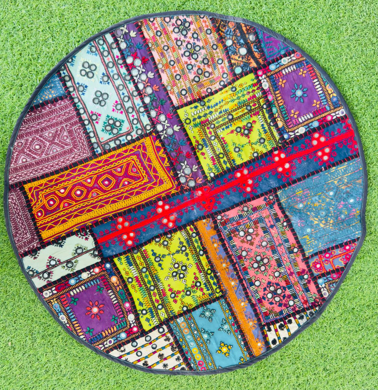 Round textile wall hanging assembled from colourful embroidered panels